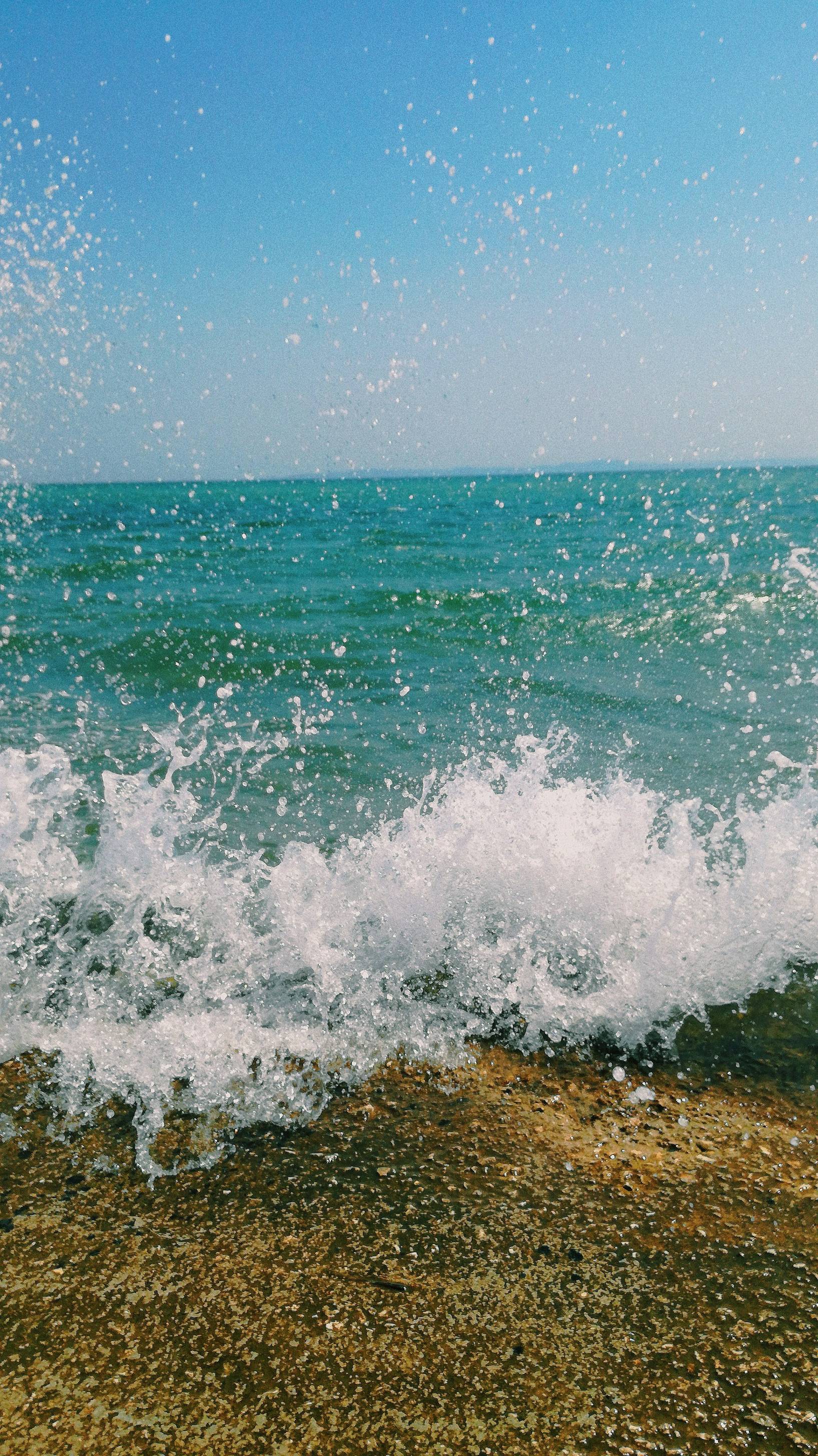 ocean waves crashing on shore during daytime
