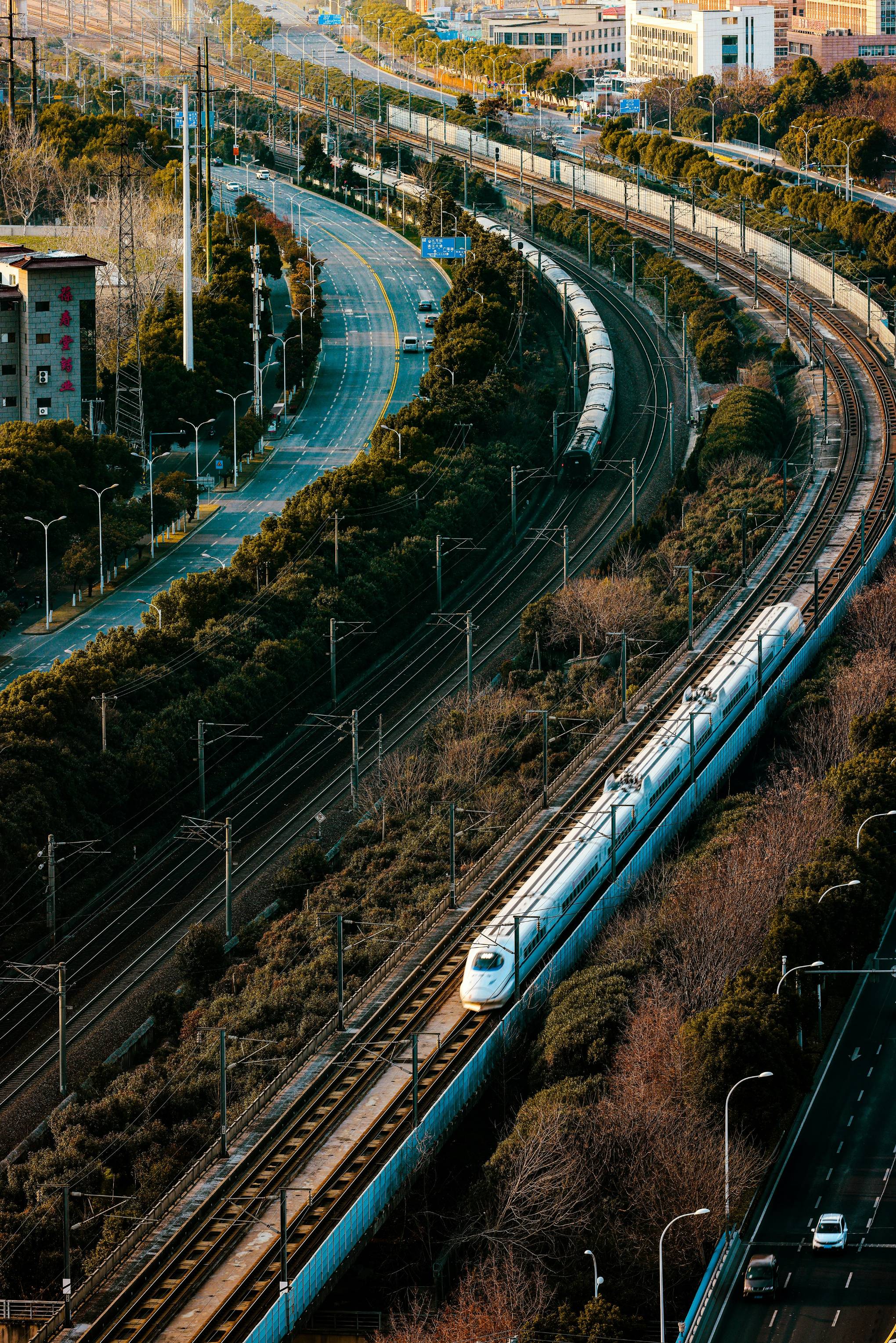 a train traveling down tracks next to a lush green hillside