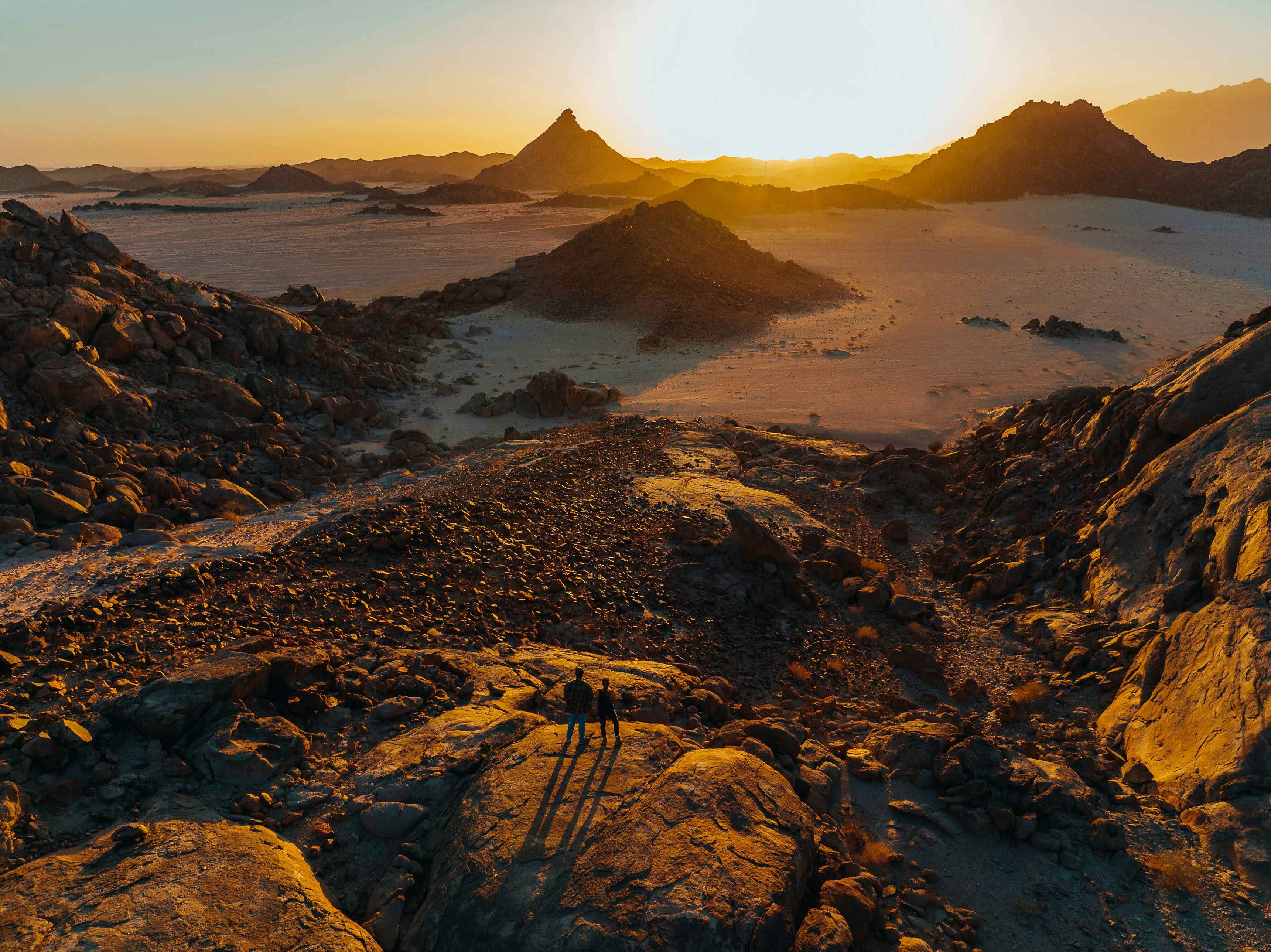 the sun is setting over a desert landscape