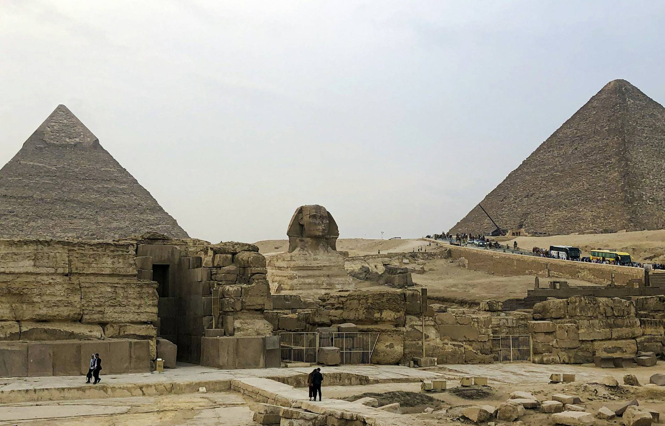 a group of people standing in front of two pyramids