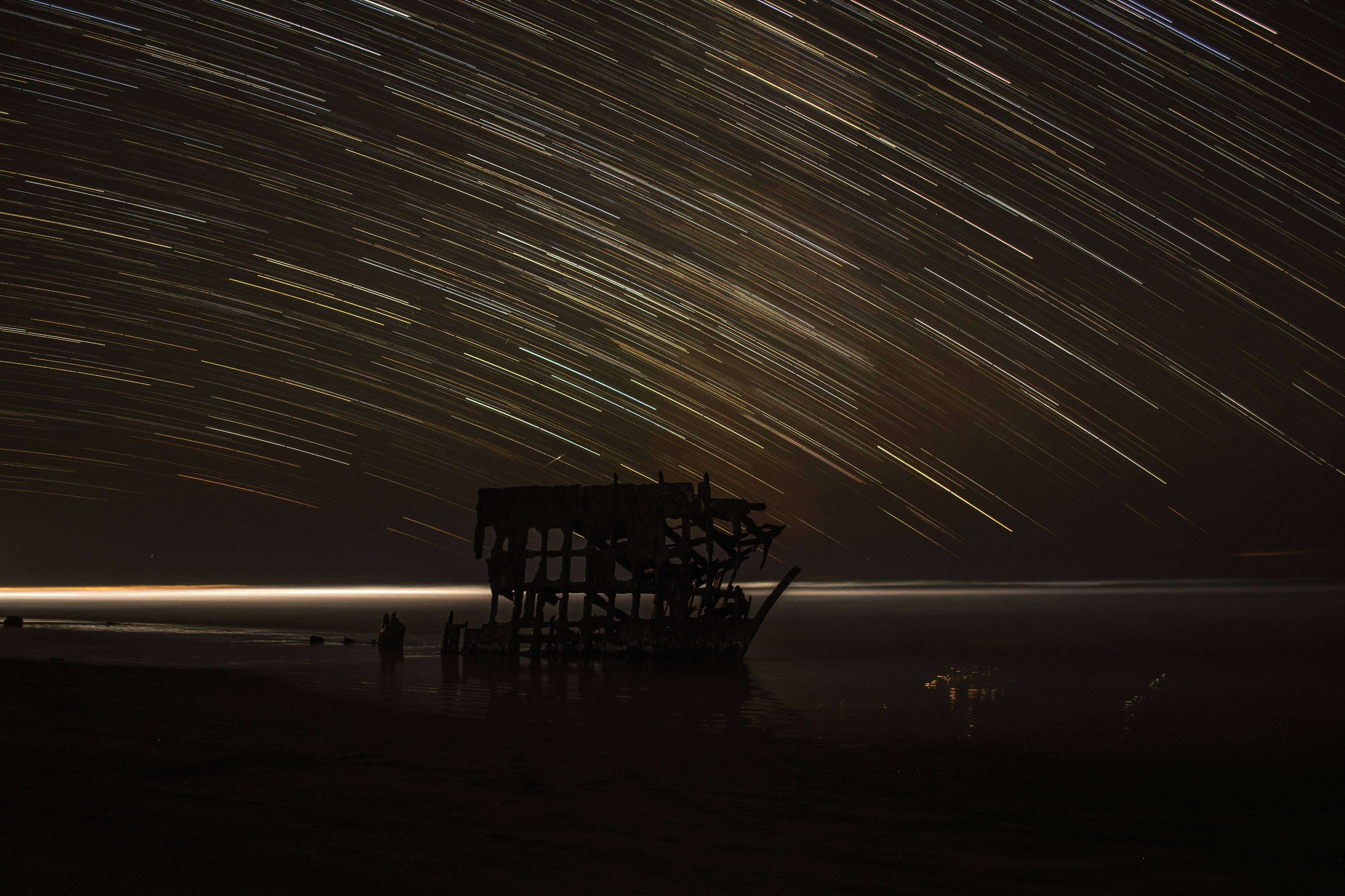 time lapse photography of house with shooting star at night time
