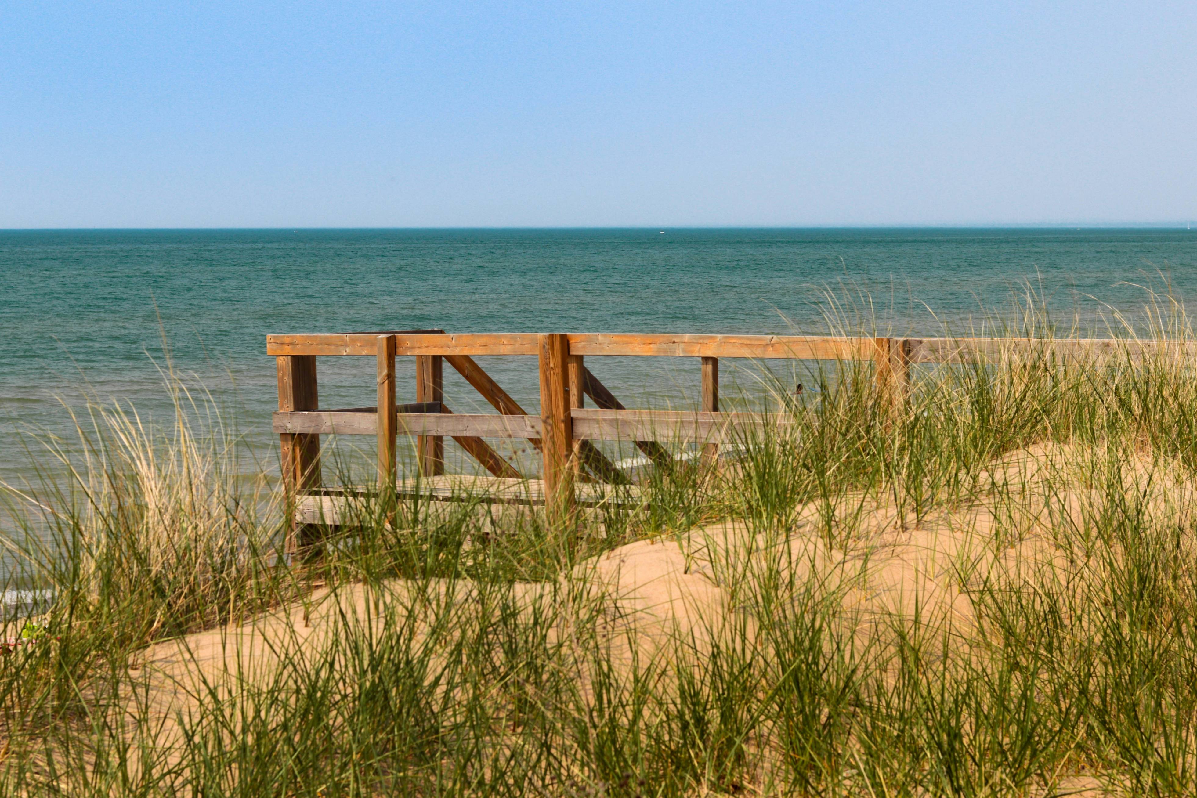 a wooden bench sitting on top of a sandy beach