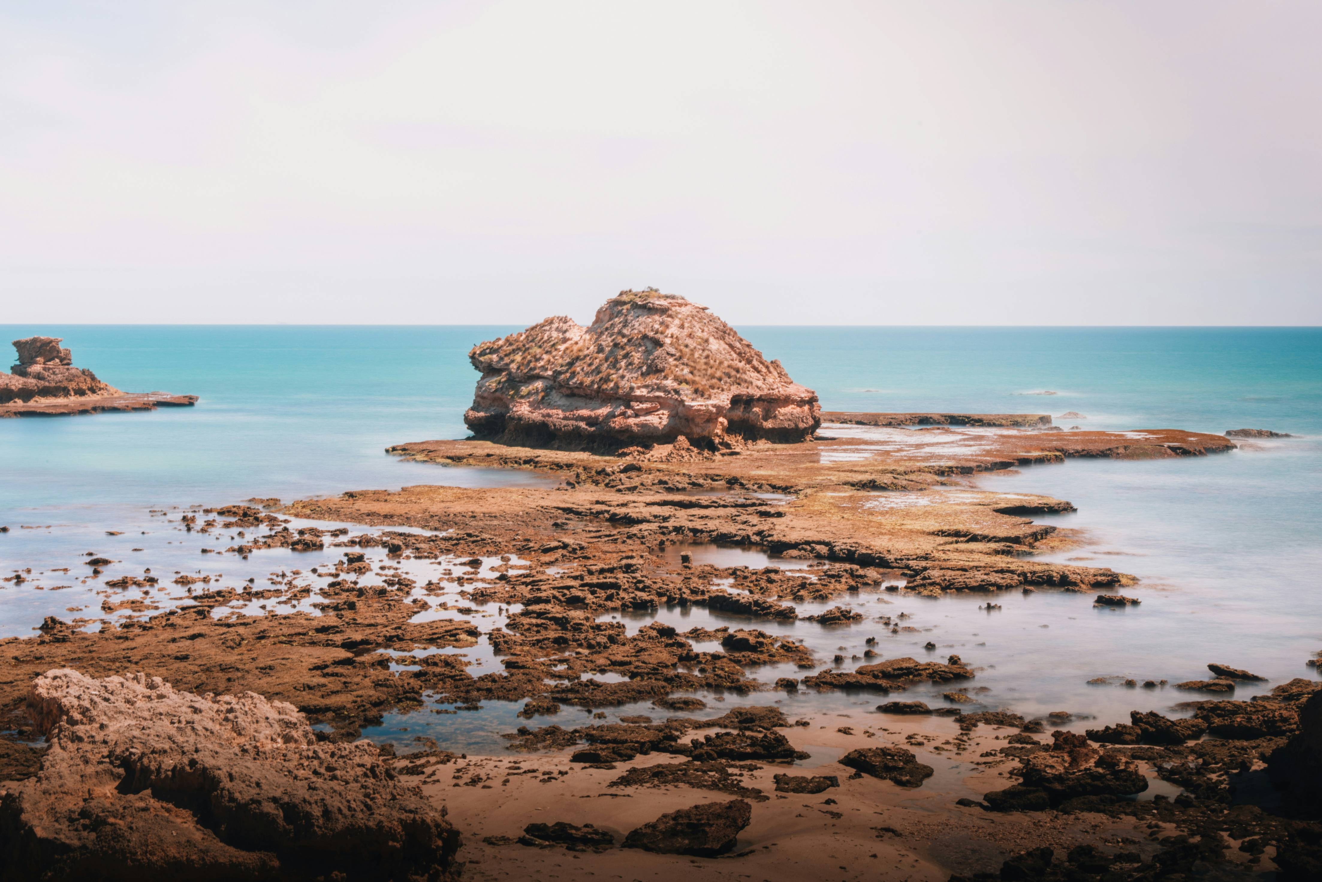 brown rock formation on sea shore during daytime