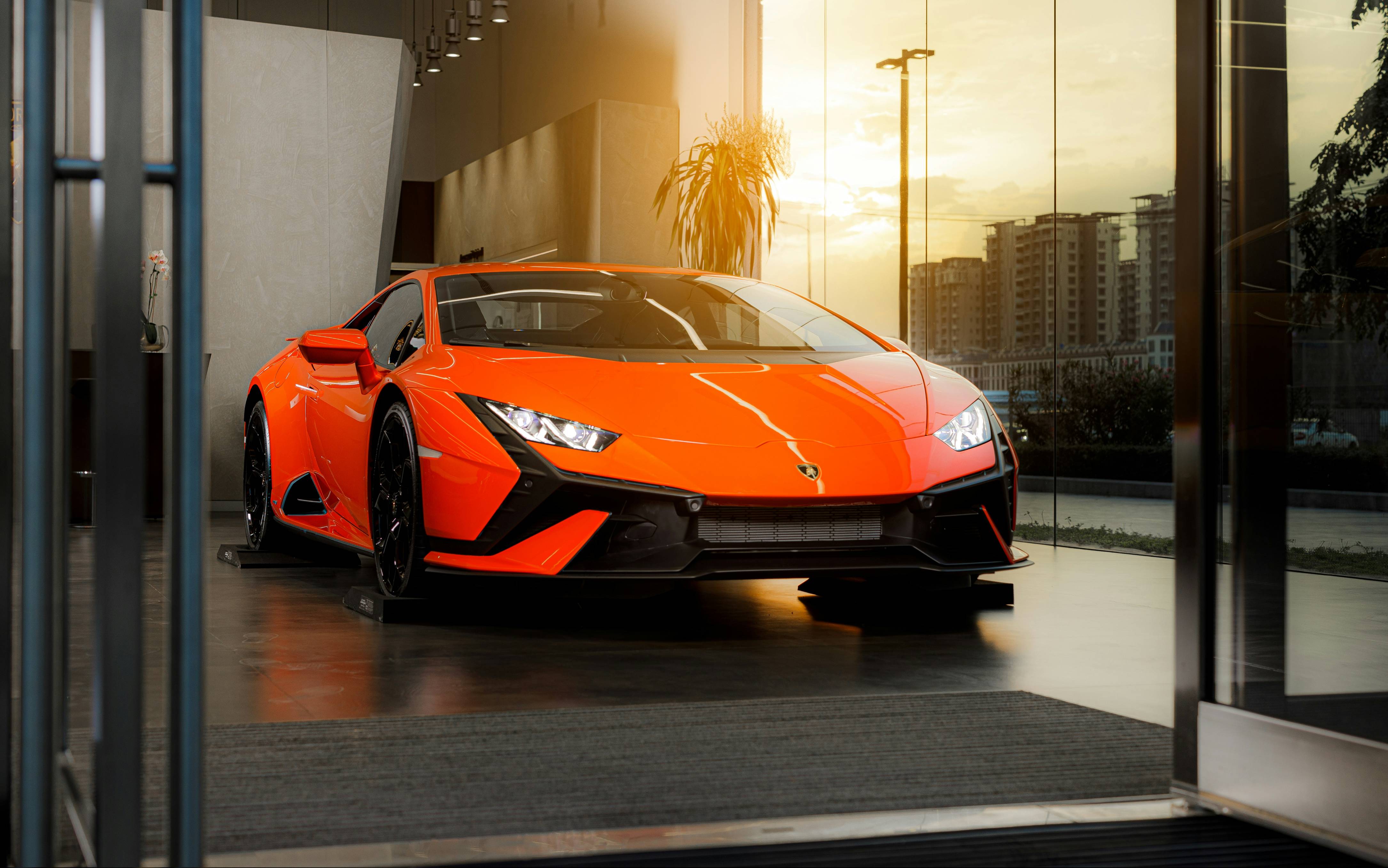 a bright orange sports car parked in front of a building
